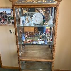 Wooden display shelf with glass doors and various