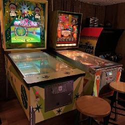 Group of vintage pinball machines and arcade games arranged in a private game room setting.